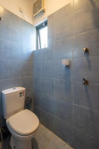 a bathroom with a toilet and a tile wall at Diplomat Suites at Heights Residencies in Narahenpita