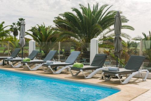 カレタ・デ・フステにあるCasa Africaのスイミングプールの横のラウンジチェアとパラソル