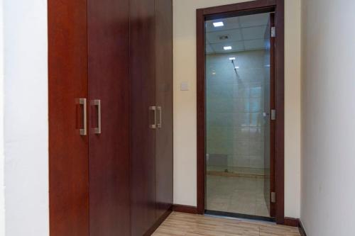 Aspire Tower - Spacious One Bedroom Apartment في المنامة: زوج من الأبواب الخشبية في غرفة مع مرآة