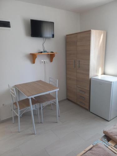 a dining room with a table and a refrigerator at BB64 Apartmanház in Békéscsaba