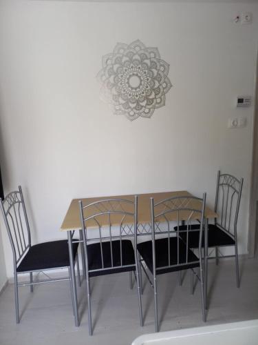 a dining room table with chairs and a chandelier at BB64 Apartmanház in Békéscsaba