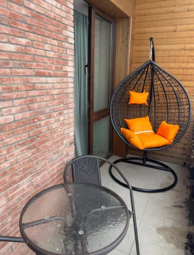 a swing with orange pillows sitting on a patio at თბილისი in Bakuriani
