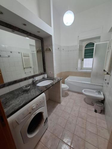 a bathroom with a sink and a washing machine at Casa Mare Roma in Lido di Ostia