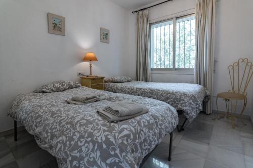 sypialnia z dwoma łóżkami i oknem w obiekcie Villa Paradise close to Puerto Banus w Marbelli
