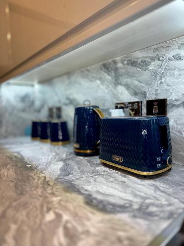 a row of blue suitcases sitting on a shelf at Luxxe House with Hot tub and Pool table in Uxbridge