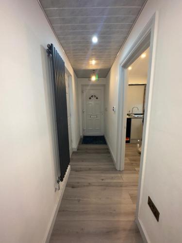 a hallway with a hallway leading to a door at Luxxe House with Hot tub and Pool table in Uxbridge