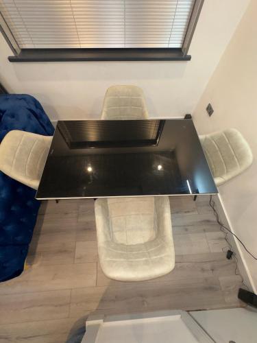 a black table with white chairs in a room at Luxxe House with Hot tub and Pool table in Uxbridge