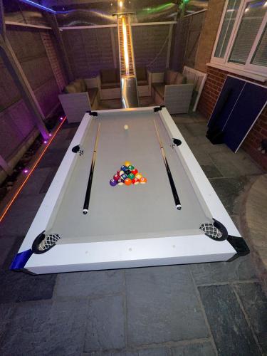 a pool table with cue balls on top of it at Luxxe House with Hot tub and Pool table in Uxbridge