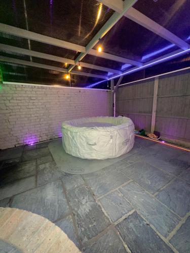 a room with a large mattress in a room with purple lights at Luxxe House with Hot tub and Pool table in Uxbridge