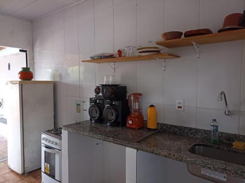 a kitchen with a counter with a microwave and a stove at Apartamento e suítes Itacaré in Itacaré