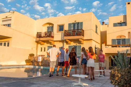 a group of people standing in front of a house at Porto Sisi Hotel Apartments in Sissi