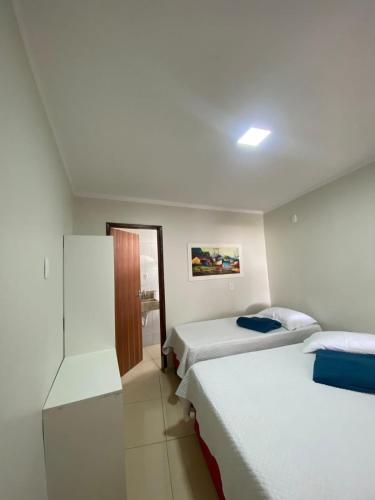 a hotel room with two beds and a bathroom at Espaço d Lurdes in Piranhas