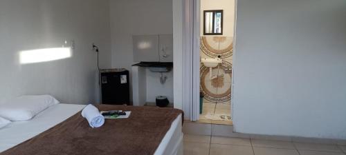 a bedroom with a bed and a door to a bathroom at Apartamento e suítes Itacaré in Itacaré