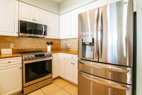 a kitchen with a stainless steel refrigerator and white cabinets at Penthouse Stunning Ocean Views Lazy River Indoor Pool in Myrtle Beach