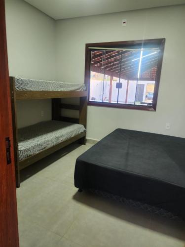 a room with two bunk beds and a window at Sítio Das Andorinhas in Capitólio