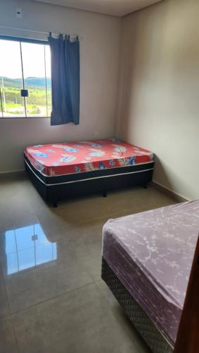 a bedroom with two beds and a window at Sítio Das Andorinhas in Capitólio