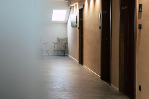an empty hallway with a row of doors and chairs at Roadhotel Vinschgau in Oris