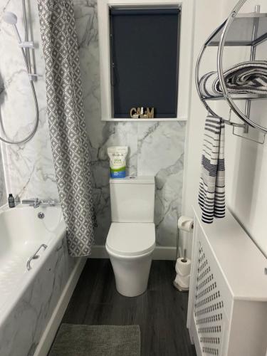 a bathroom with a toilet and a tub and a sink at Almondbank Cottage 8 miles from Portree 2 bedrooms sleeps 3 adults in Skeabost