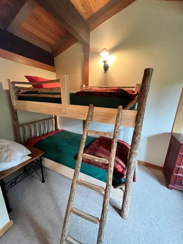 a bedroom with two bunk beds and a ladder at Sun West Lodge in Grahams Place