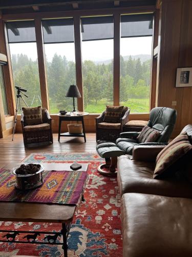 a living room with couches and a large window at Sun West Lodge in Grahams Place