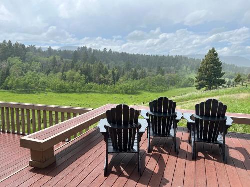 three chairs sitting on a deck with a bench at Sun West Lodge in Grahams Place