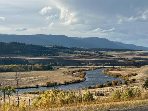 a river in a field with mountains in the background at Sun West Lodge in Grahams Place