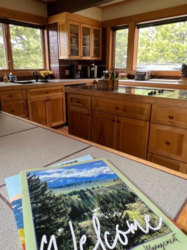 a kitchen with a table with a book on it at Sun West Lodge in Grahams Place