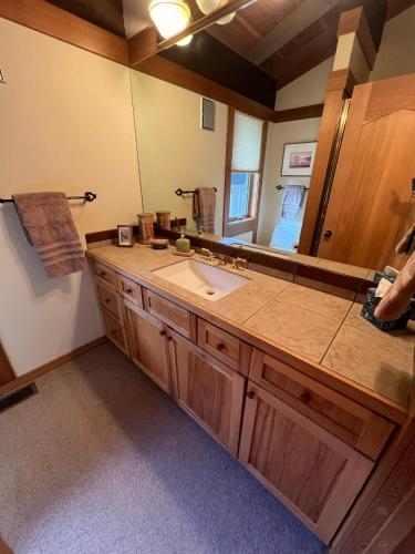 a bathroom with a sink and a large mirror at Sun West Lodge in Grahams Place