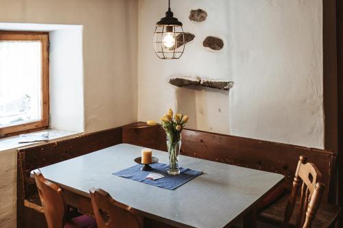 a dining room table with a vase of flowers on it at Ferienhaus MAVI in Schruns-Tschagguns