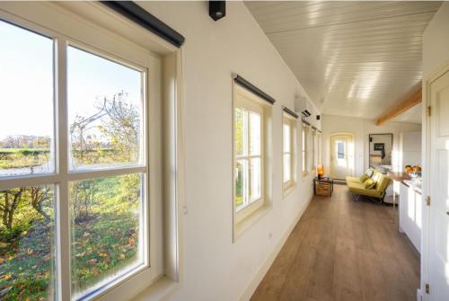 an empty hallway with large windows in a house at Natuurhuisje De kleine Varenhorst in Breedenbroek