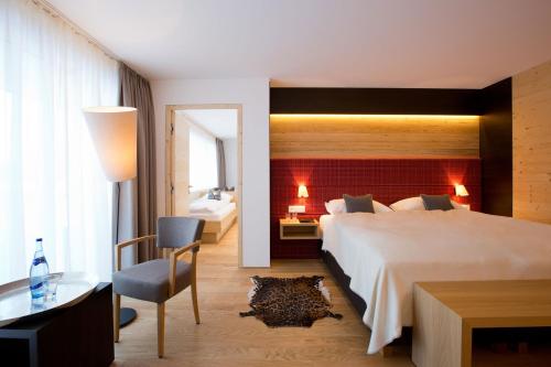 una camera d'albergo con un grande letto e una scrivania di Hotel Walserstube a Warth am Arlberg