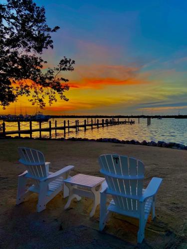 two chairs and a table on the beach at sunset at Coconut Palm Inn in Key Largo