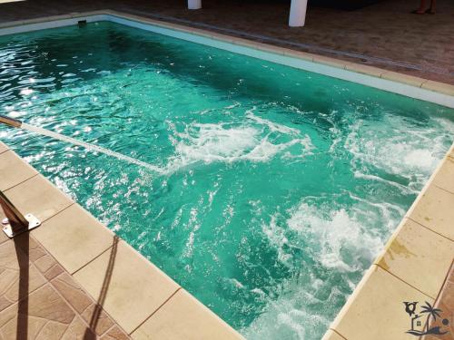 una piscina de agua azul turquesa con olas en Villa Queca Private heated pool cannon water and jacuzzi, en Santa Cruz de Tenerife