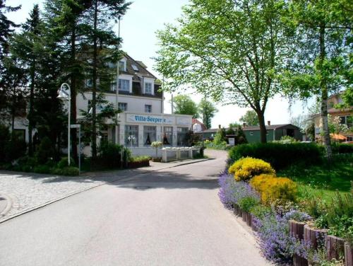a street in front of a building with flowers at Villa Seeperle - Sturmvogel in Dahme