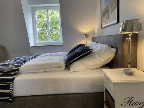 a bedroom with a bed with pillows and a window at Villa Seeperle - Sturmvogel in Dahme