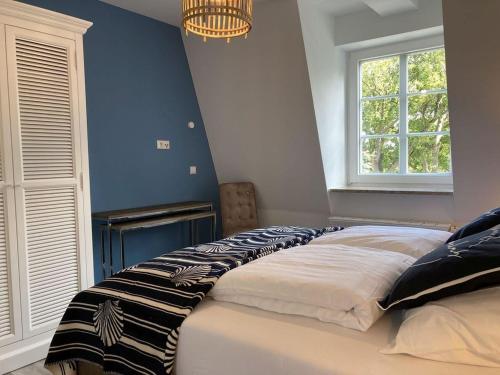 a bedroom with a large bed with a blue wall at Villa Seeperle - Sturmvogel in Dahme