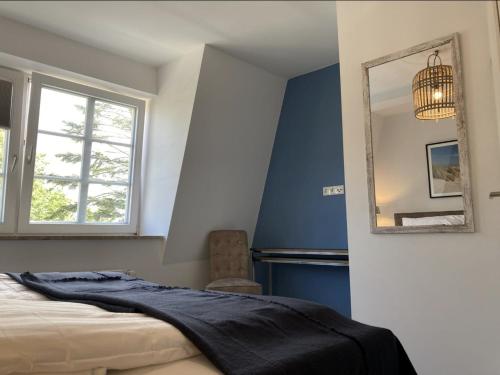 a bedroom with blue walls and a bed and a mirror at Villa Seeperle - Sturmvogel in Dahme