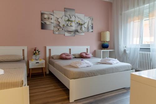 two beds in a bedroom with pink walls at Casa San Marco in Lucca