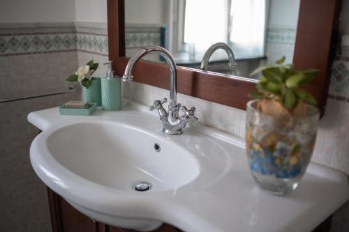 a white bathroom sink with a vase on it at Casa San Marco in Lucca