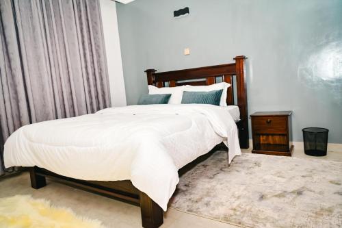 a bedroom with a large bed and a night stand at Sunninghills in Nairobi