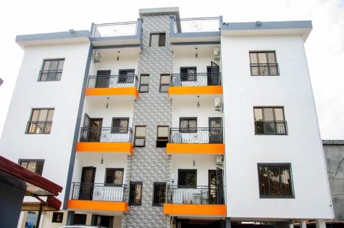 a white building with orange balconies on it at Nesbitt Luxury in Mbala