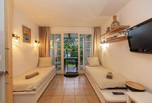 un salon avec deux canapés et une télévision à écran plat dans l'établissement Atlantic Selection - Domaine de Bordaberry - Terrasse & superbe piscine, à Urrugne