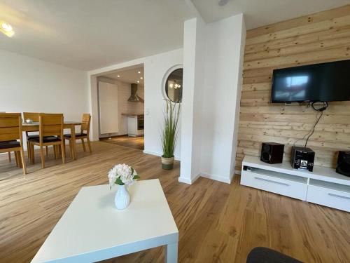 a living room with a white table and a tv on a wall at Ferienwohnung zum Sepp in Mühlheim an der Donau