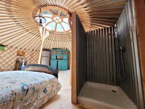 - une chambre avec un lit dans une yourte dotée d'une fenêtre dans l'établissement Gîte de France La yourte joulebois - Gîte de France 2 personnes MAE-6961, à Saillac