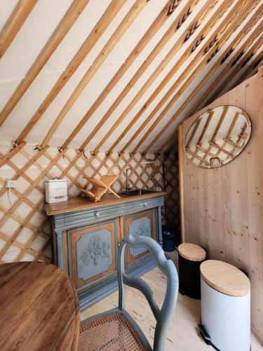 Cette chambre mansardée comprend une table et une chaise. dans l'établissement Gîte de France La yourte joulebois - Gîte de France 2 personnes MAE-6961, à Saillac