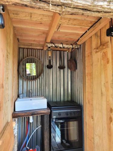 une cuisine avec un évier et une cuisinière dans l'établissement Gîte de France La yourte joulebois - Gîte de France 2 personnes MAE-6961, à Saillac
