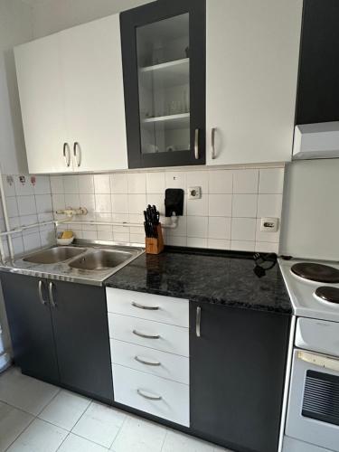 a kitchen with white cabinets and a sink at Apartment Crystal in Belgrade