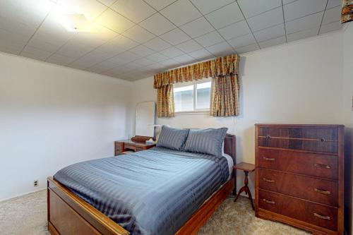 a bedroom with a bed and a dresser and a window at Blue Heron in Lona Beach