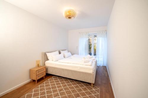 a bedroom with a white bed and a window at LIBORIA I Stylisches Haus I Sauna I Wellness in Starnberg