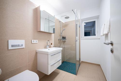 a bathroom with a shower and a toilet and a sink at LIBORIA I Stylisches Haus I Sauna I Wellness in Starnberg